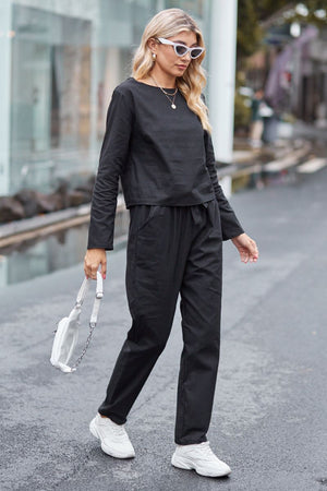Woman wearing black cotton-linen monochrome capsule set with longline top and wide-leg pants walking on street