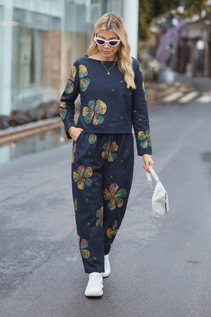 woman wearing dark cotton-linen monochrome capsule outfit with colorful floral prints walking on street with white sneakers and sunglasses