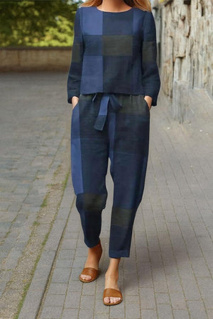 Woman wearing navy blue cotton-linen monochrome relaxed longline top and wide-leg pants set with brown sandals walking outdoors