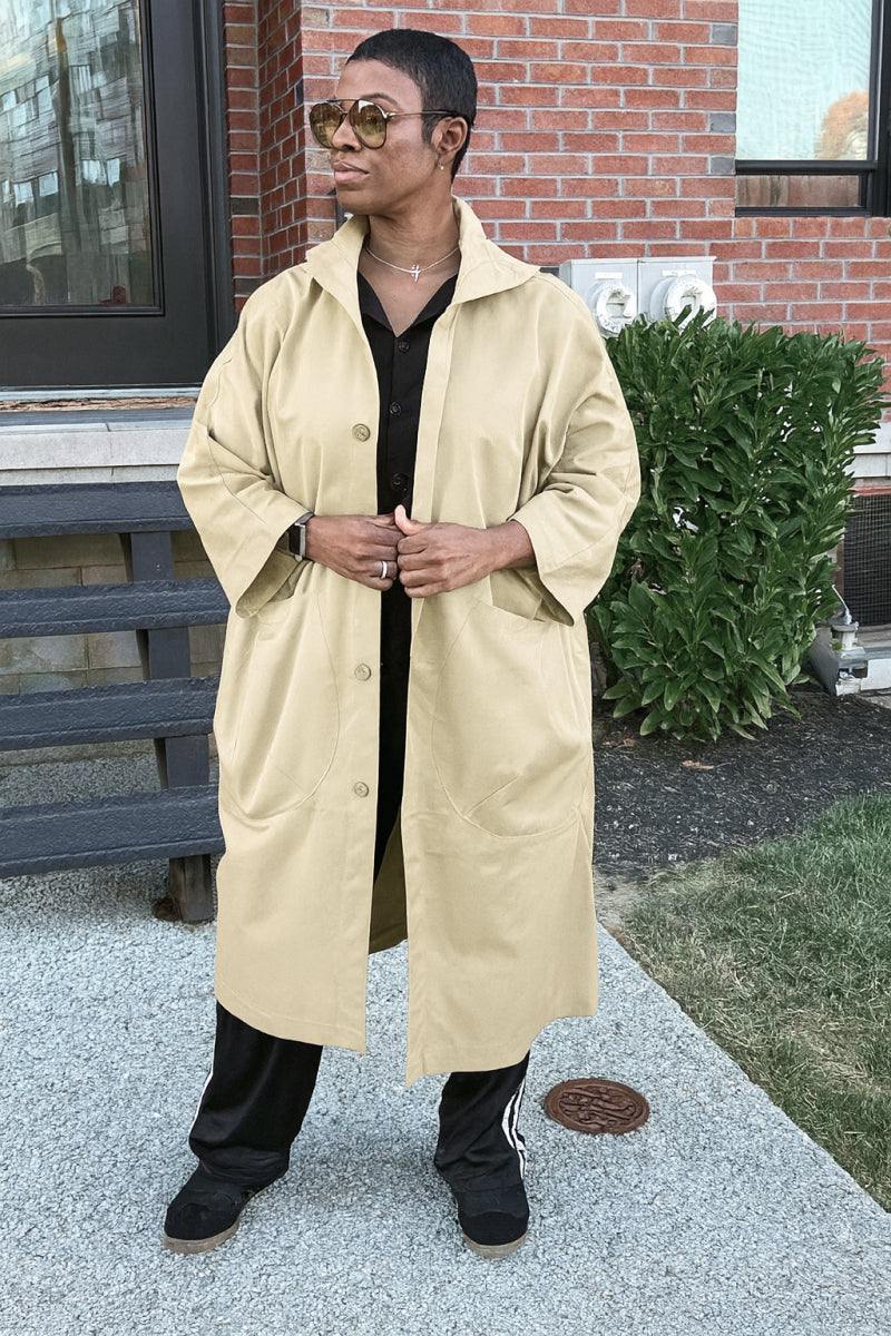 One size fits all oversized water resistant windbreaker jacket in beige with snap-button closure and attached hood, styled for casual outdoor wear.