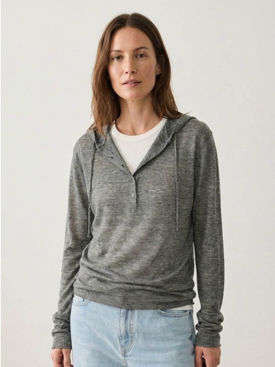 Organic linen Henley top with fine knit, relaxed fit, 3-button placket, long sleeves, and side slits in neutral heathered tones.