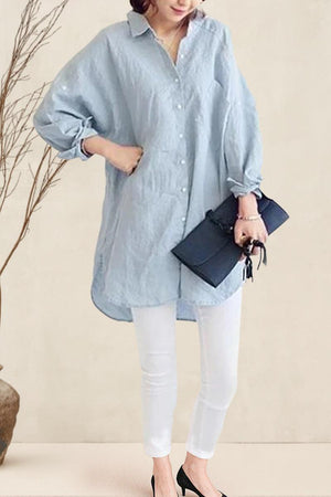 Oversized linen shirt in light blue with relaxed fit, long sleeves, button front, styled with white pants and black heels.