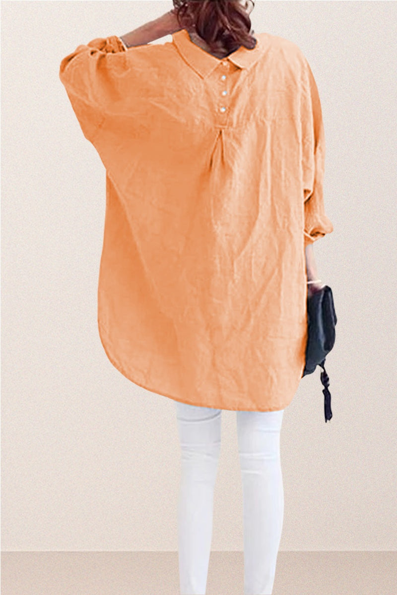Woman wearing oversized linen shirt in sun-washed pink with gathered back and buttons, paired with white pants.