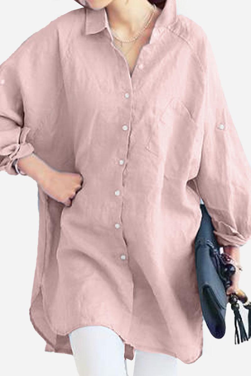 Pink oversized linen shirt with long sleeves and front pocket, styled casually with rolled-up sleeves and white pants.