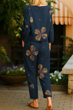 Woman wearing a retro patterned linen two-piece set with floral designs in navy blue outdoors