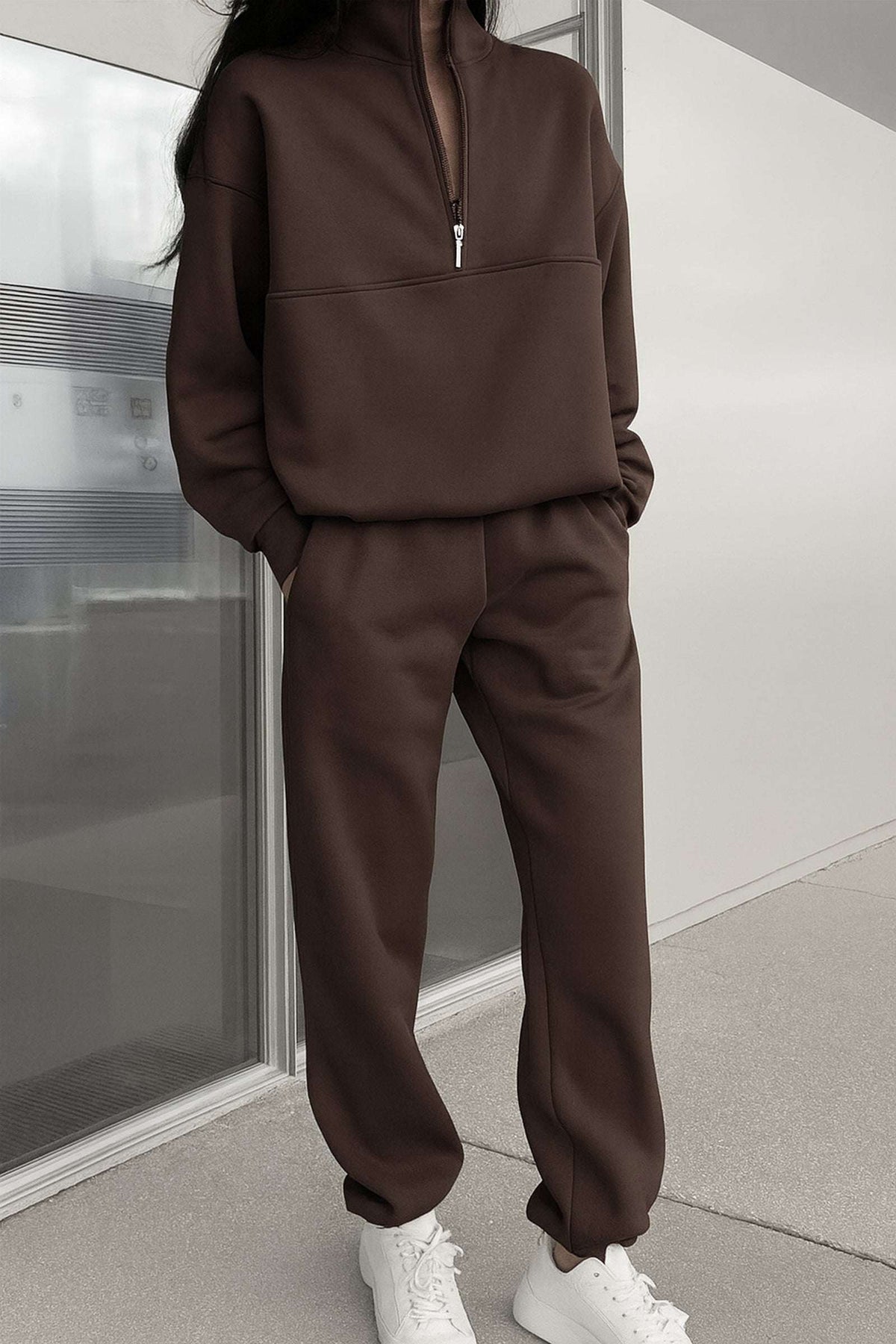 brown cotton blend tracksuit with zip neckline and relaxed fit modeled with white sneakers