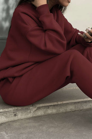 Burgundy cotton blend tracksuit with relaxed fit and minimal design, featuring stretch waistband and cuffs for tailored comfort.