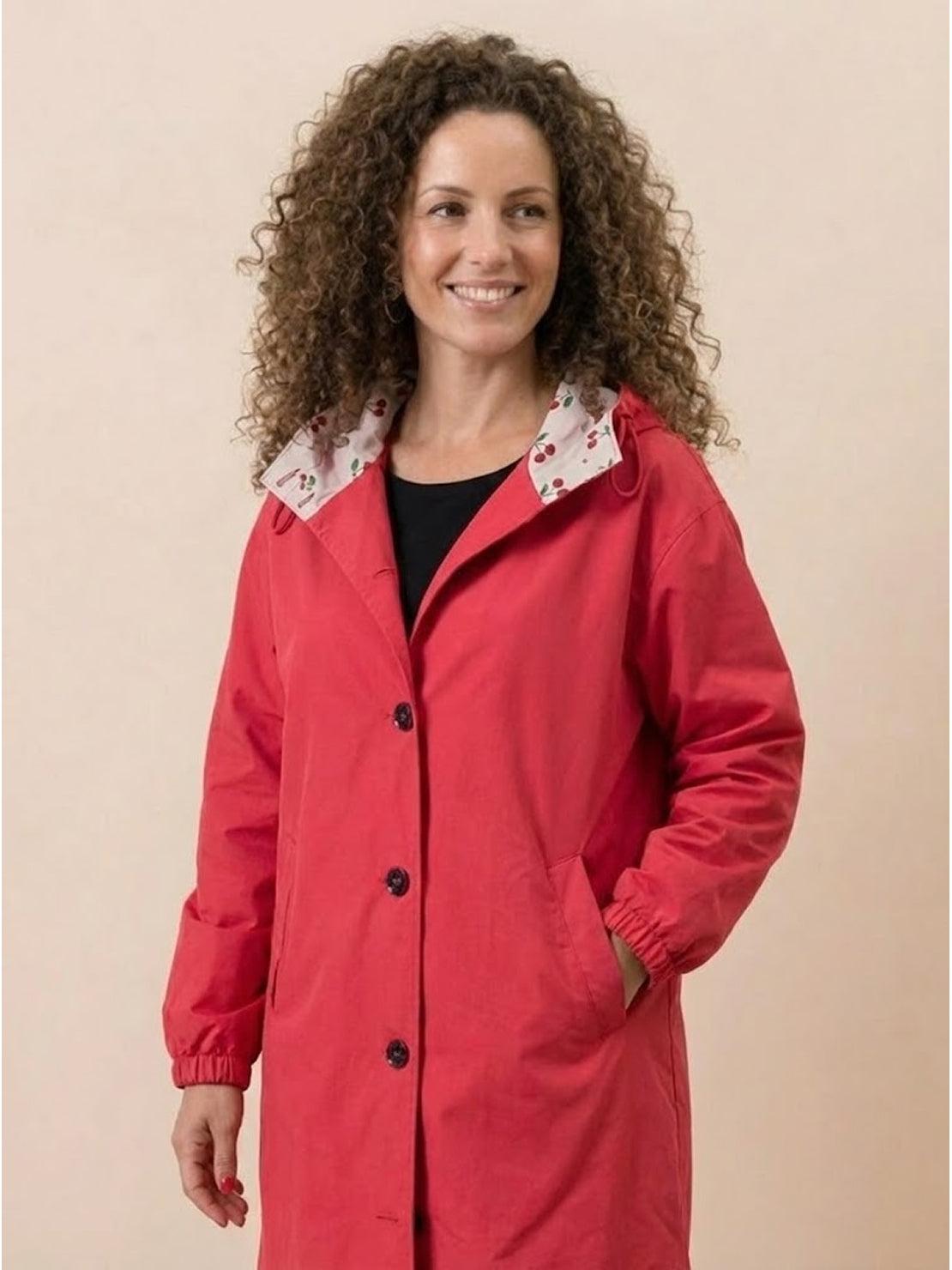 Woman wearing red oversized Rain Couture Windbreaker jacket with button front and adjustable hood