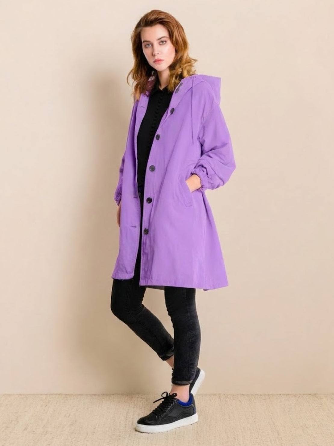 Woman wearing purple oversized Rain Couture Windbreaker with hood and black casual outfit