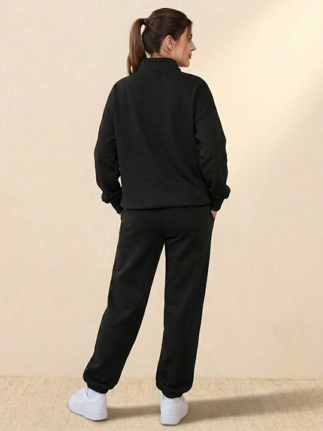 Woman wearing black ultra-soft and comfy co-ord tracksuit set with white sneakers, viewed from back