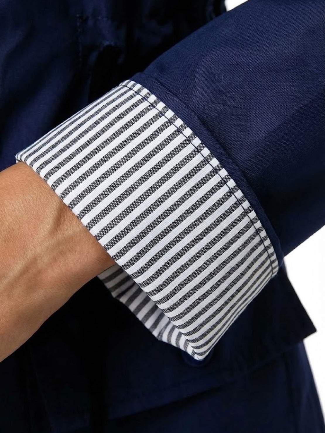 Close-up of striped cuff on navy water resistant windbreaker jacket sleeve for women
