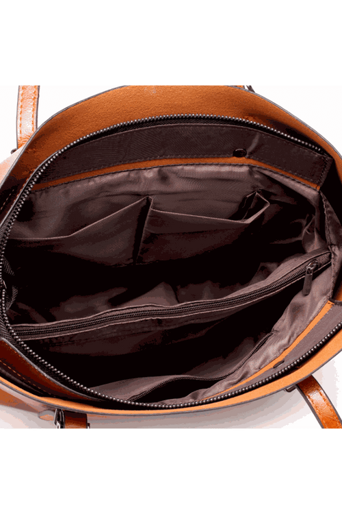 Interior view of a multi strap tote bag showing multiple compartments and brown lining fabric.
