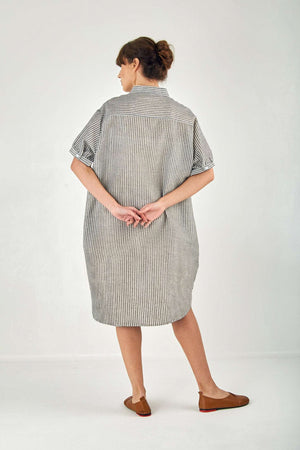 Woman wearing a striped gauze shirt dress made of linen cotton blend, featuring short sleeves and knee length in an oversized fit.