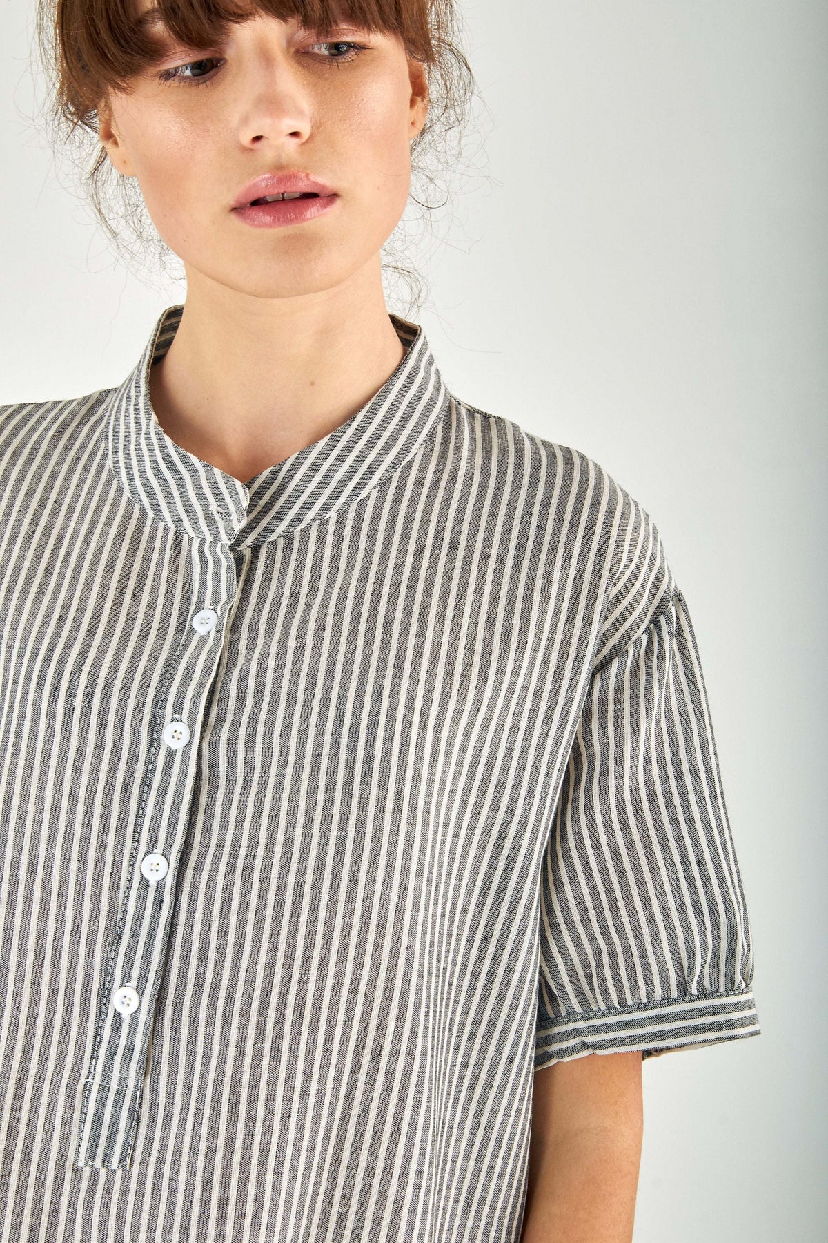Close-up of striped gauze shirt dress with stand-up collar and button fastening in linen cotton blend fabric