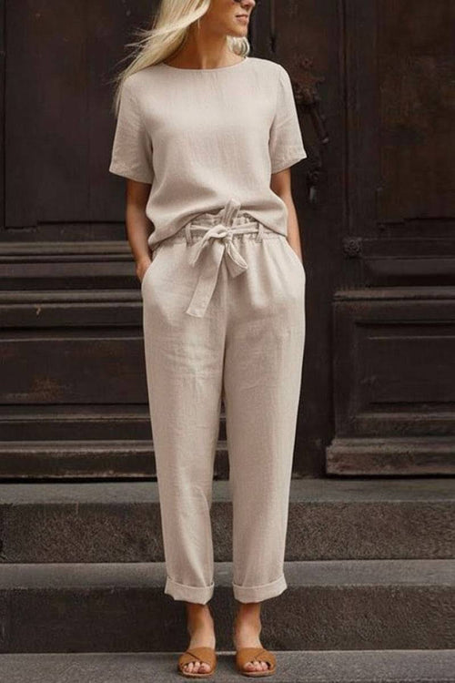 Woman wearing beige cotton linen set with short-sleeve top and straight-leg pants with drawstring waist