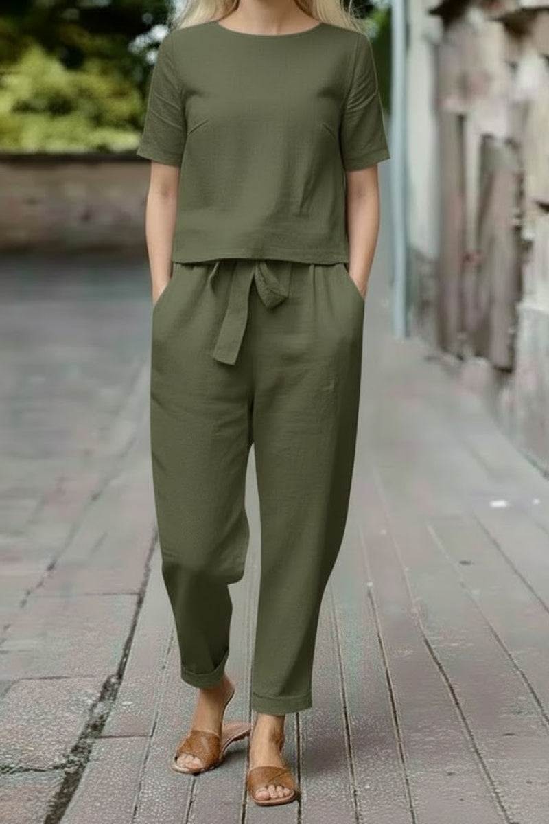 Woman wearing olive green cotton linen set with short-sleeve top and straight-leg pants outdoors