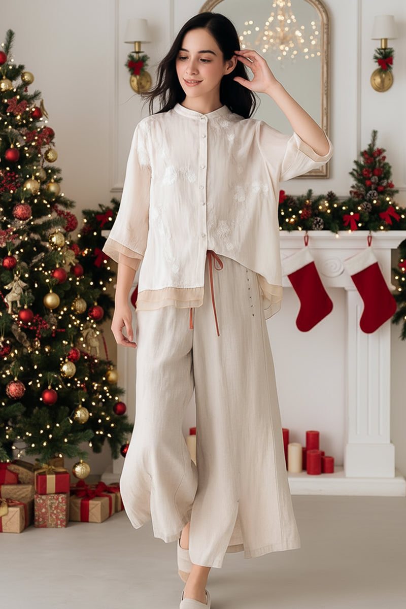 woman wearing 100% cotton linen Tuscany two-piece set with sheer embroidered top and wide-leg trousers in festive Christmas room