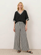 Model wearing striped wide-leg co-ord set with oversized top and palazzo pants with elastic waist and side pockets