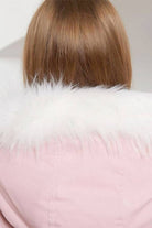 Back view of pink thick long-sleeve zipper overcoat with white fur collar on woman