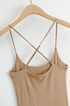 Beige elegant side slit midi dress with crisscross suspender straps on wooden hanger