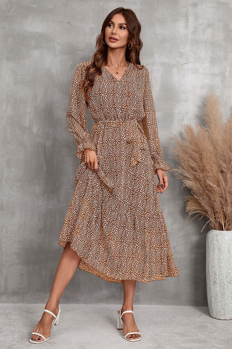 Woman wearing a brown floral Bloom Wrap Midi Dress with long trumpet sleeves and an A-line silhouette