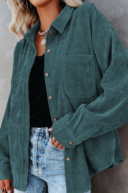 woman wearing a teal sleek suede oversized button-down shirt with front pocket and buttons paired with black top and denim jeans