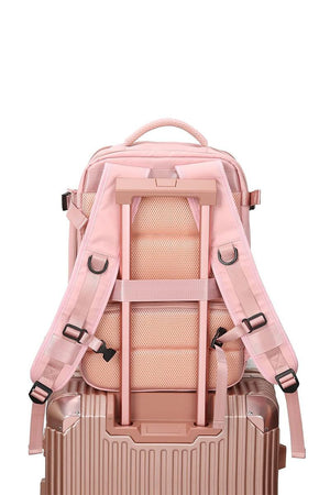 Chic Wanderlust Waterproof Backpack in pink shown attached to suitcase handle with padded ergonomic straps and breathable back panel.
