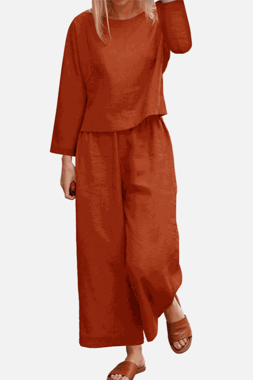woman wearing loose solid color two-piece set with wide-leg pants and long sleeve top in burnt orange