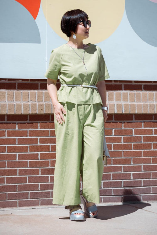 Woman wearing light green loose fit co-ord set with wide-leg pants and short-sleeve top outdoors