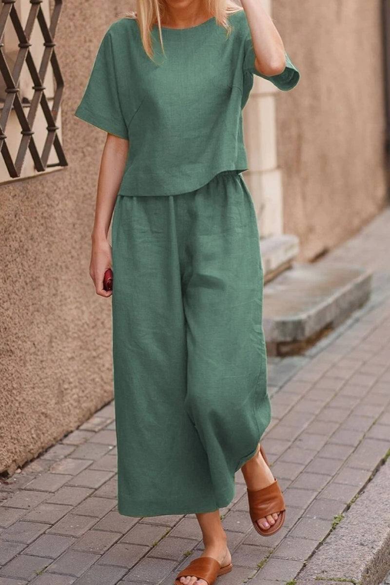 Woman wearing green loose fit co-ord set with wide-leg pants and short-sleeve top walking outdoors