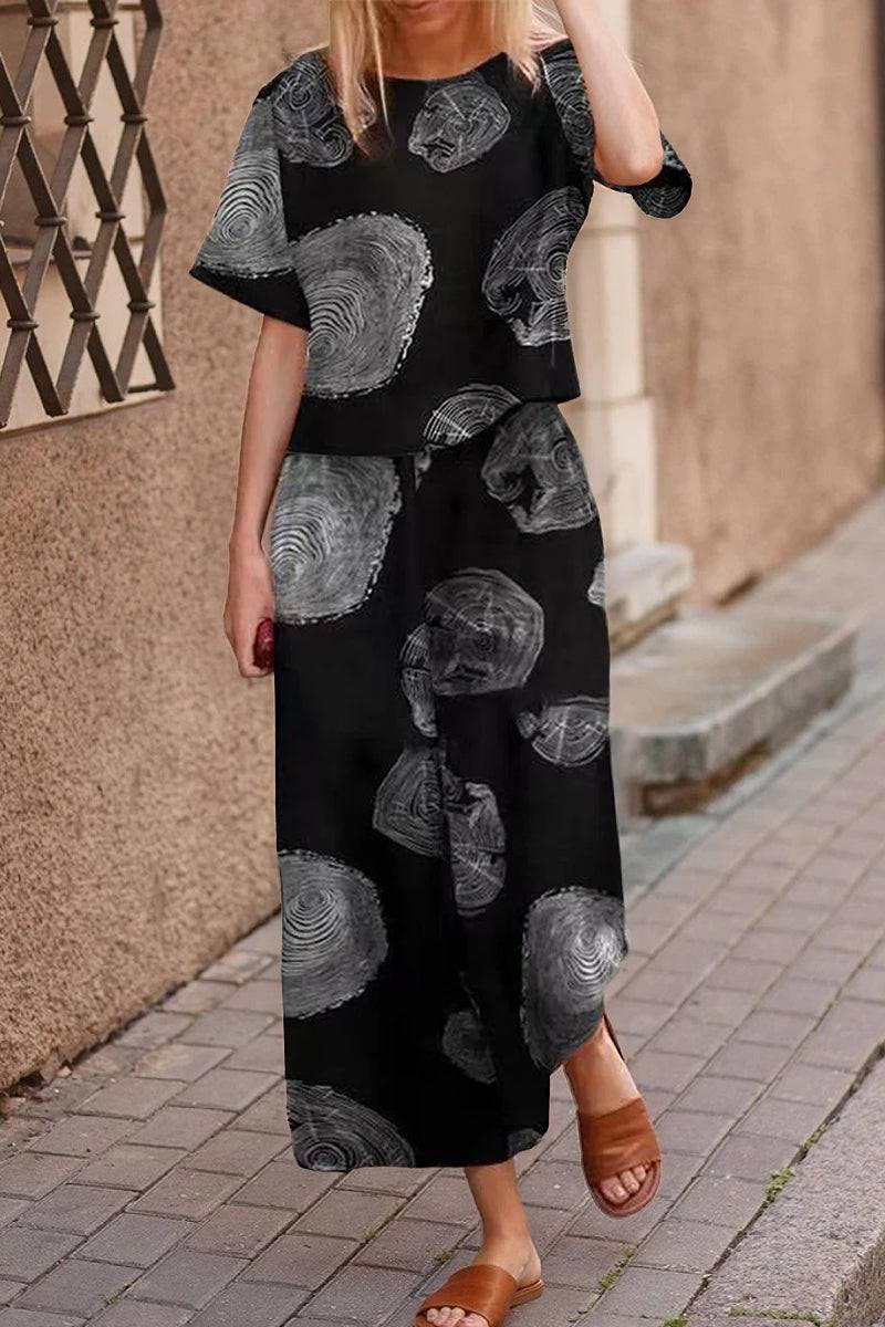 Woman wearing black floral print loose fit co-ord set with wide-leg pants and short-sleeve top