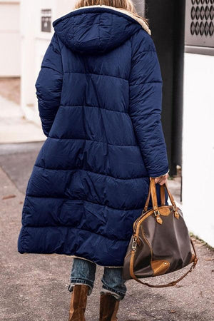 Women wearing navy Sherpa-lined hooded teddy coat with puffer design and large pockets, carrying brown handbag outdoors