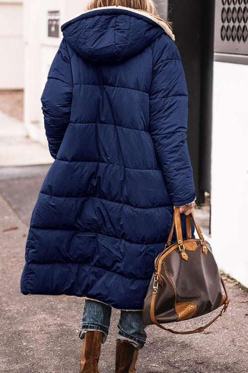 Women wearing navy Sherpa-lined hooded teddy coat with puffer design and large pockets, carrying brown handbag outdoors