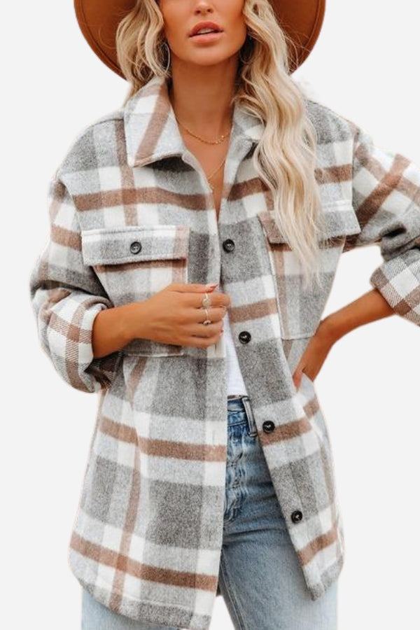 Woman wearing a comfy flannel classic button-down shirt with gray, white, and brown plaid pattern paired with jeans and a brown hat