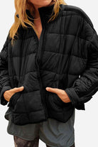 Black lightweight puffer travel jacket with quilted design and zip-up front worn by model