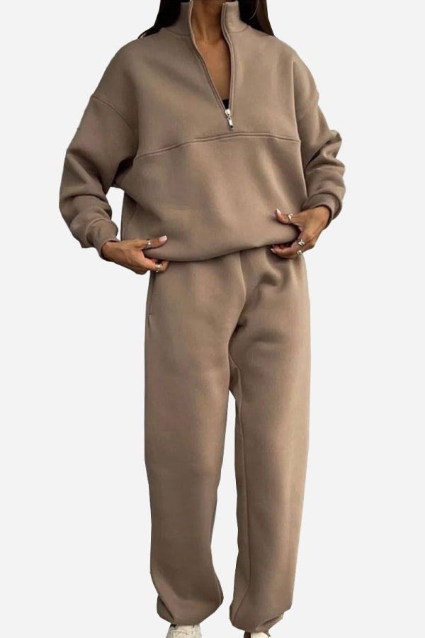 Woman wearing beige cotton-blended two-piece tracksuit with high collar and zipper detail
