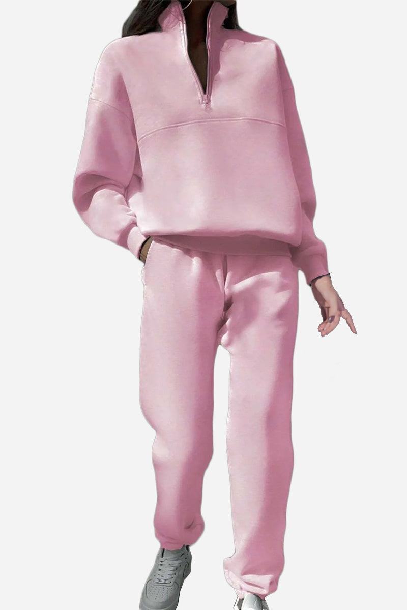 Pink cotton-blended two-piece tracksuit with high collar and zipper, styled with sneakers.