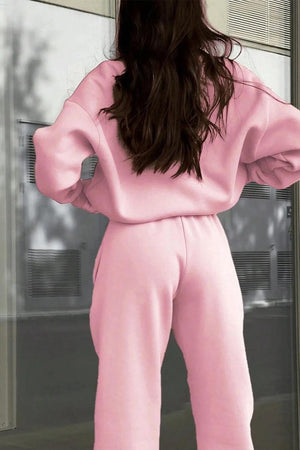 Woman wearing pink cotton-blended two-piece tracksuit from the back outdoors