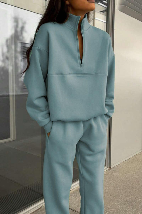 woman wearing light blue cotton-blended two-piece tracksuit with high collar and zipper standing outdoors
