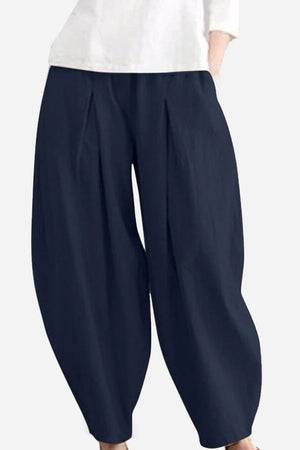 Solid color wide leg cotton pleated pants in navy blue with a voluminous fit and comfortable breathable fabric