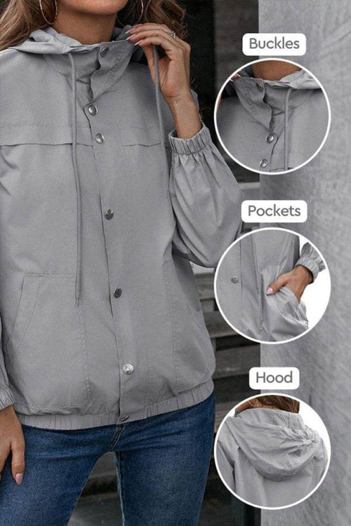 Light grey outdoor hooded raincoat with adjustable hood, button buckles, elastic cuffs, and pockets for weather protection.