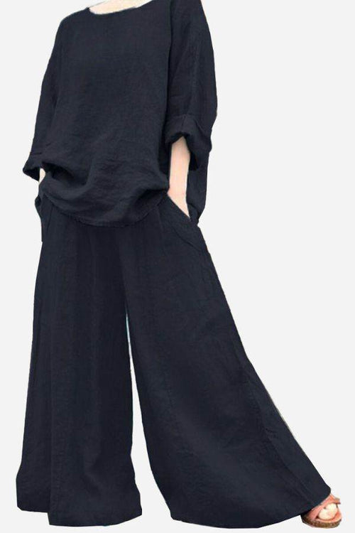 Black wide leg pants with pockets paired with loose black top, bohemian style outfit
