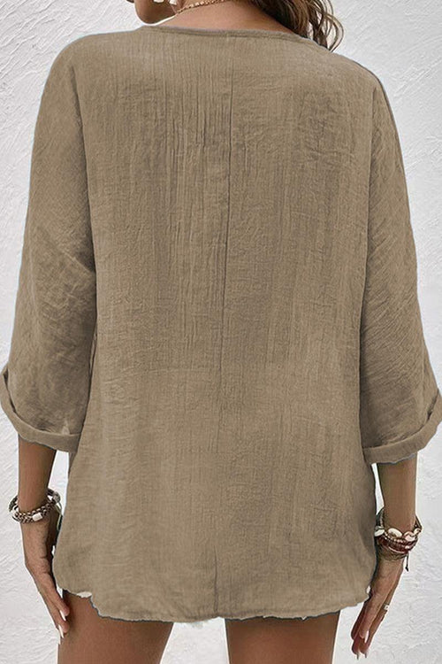 Back view of beige artisanal crinkle fabric button front tunic with rolled sleeves