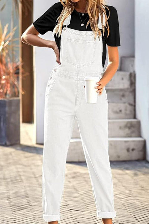White denim-look tapered-leg adjustable bib overalls worn with black t-shirt holding a cup outdoors