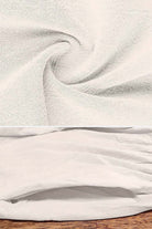 Close-up of soft, breathable fabric for capped-sleeve voluminous pleated midi dress in light beige color