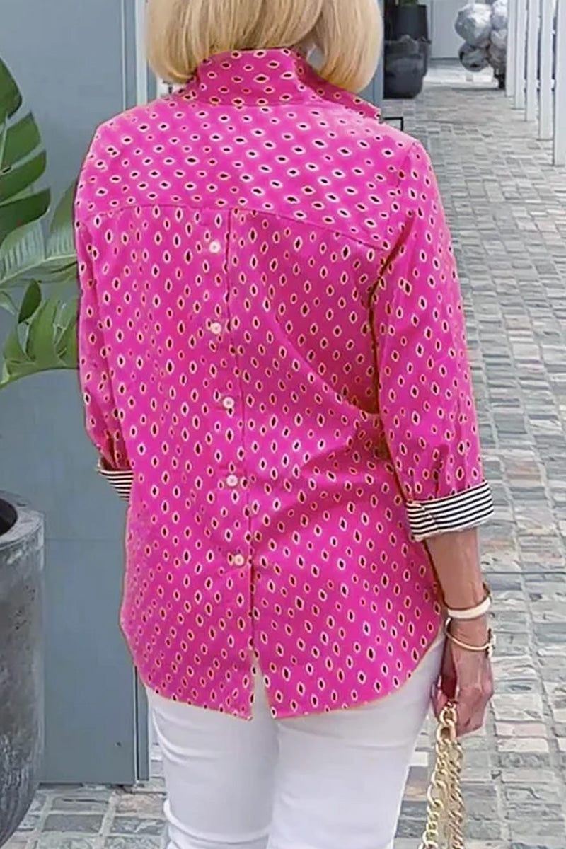 Back view of pink Boho Chic Resort Blouse with polka dots and striped cuffs on woman wearing white pants