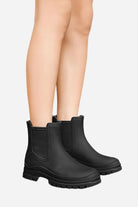 Black non-slip rain boots with SuperGrip soles on model's legs