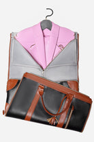 Foldable no-wrinkle travel bag in black and brown PU leather with a pink blazer inside, designed for wrinkle-free garment storage and easy transport.
