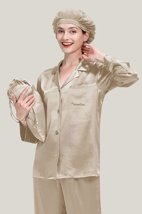 Woman wearing beige Mulberry Silk Pajama Set with matching sleep cap holding a silk pouch against neutral background