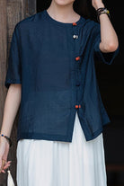 Oversized navy regenerated cellulose blouse with asymmetrical buttons, wrinkle-resistant and breathable fabric.